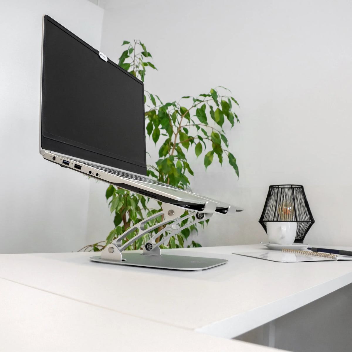 Supporto per LAPTOP STAND argentato con struttura regolabile in altezza e laptop su scrivania bianca di hjh OFFICE