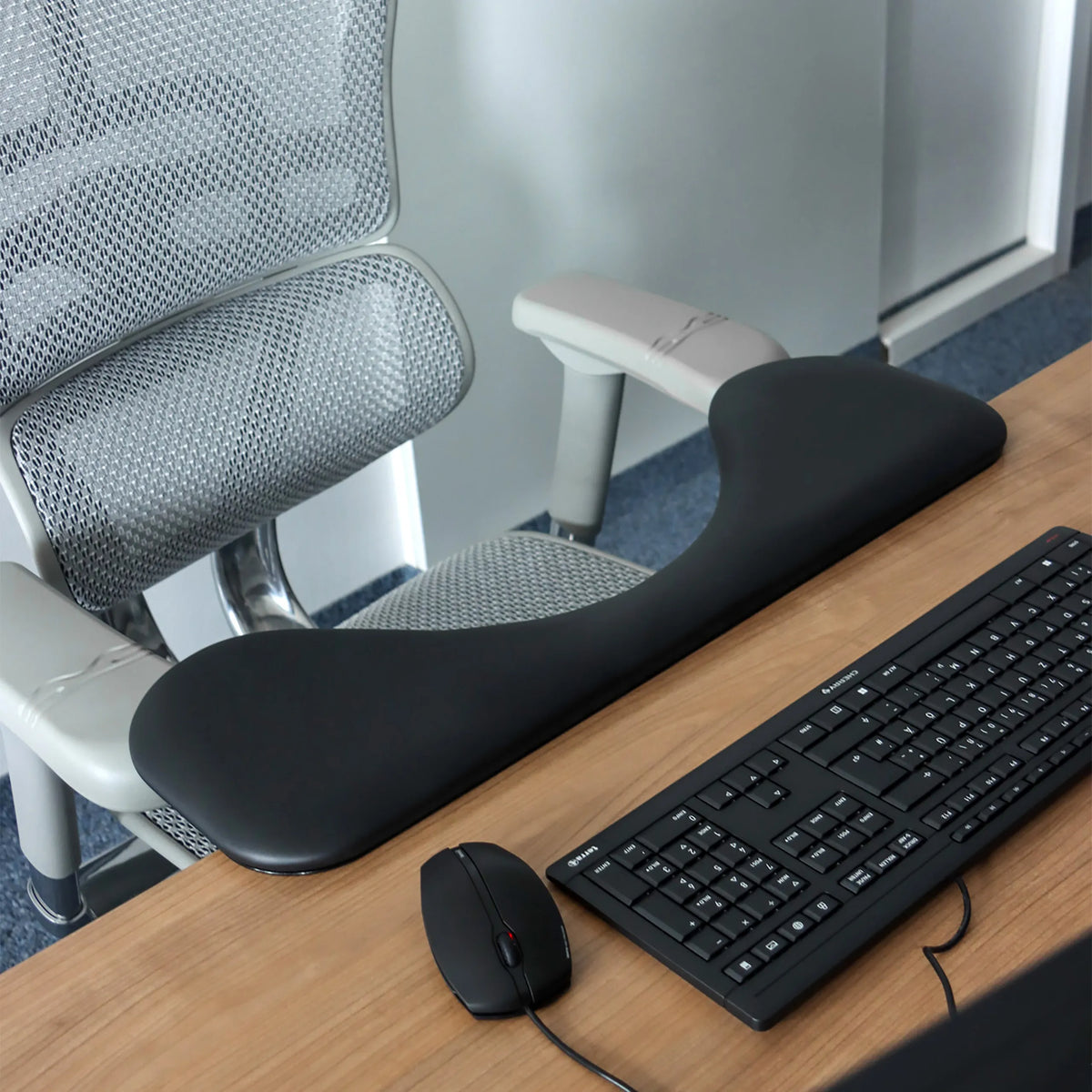 Bracciolo RELEX RT2 nero su una scrivania accanto a una tastiera e a un mouse per computer di hjh OFFICE
