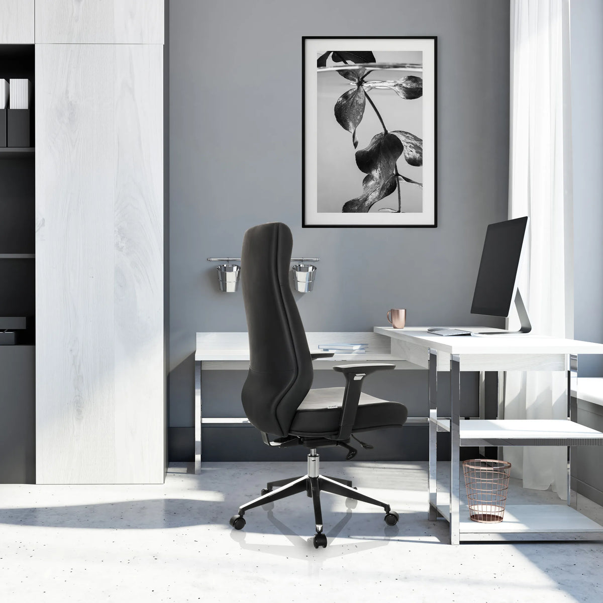 Poltrona professionale VITORO ECO in nero con schienale alto e base a stella davanti a una scrivania bianca di hjh OFFICE