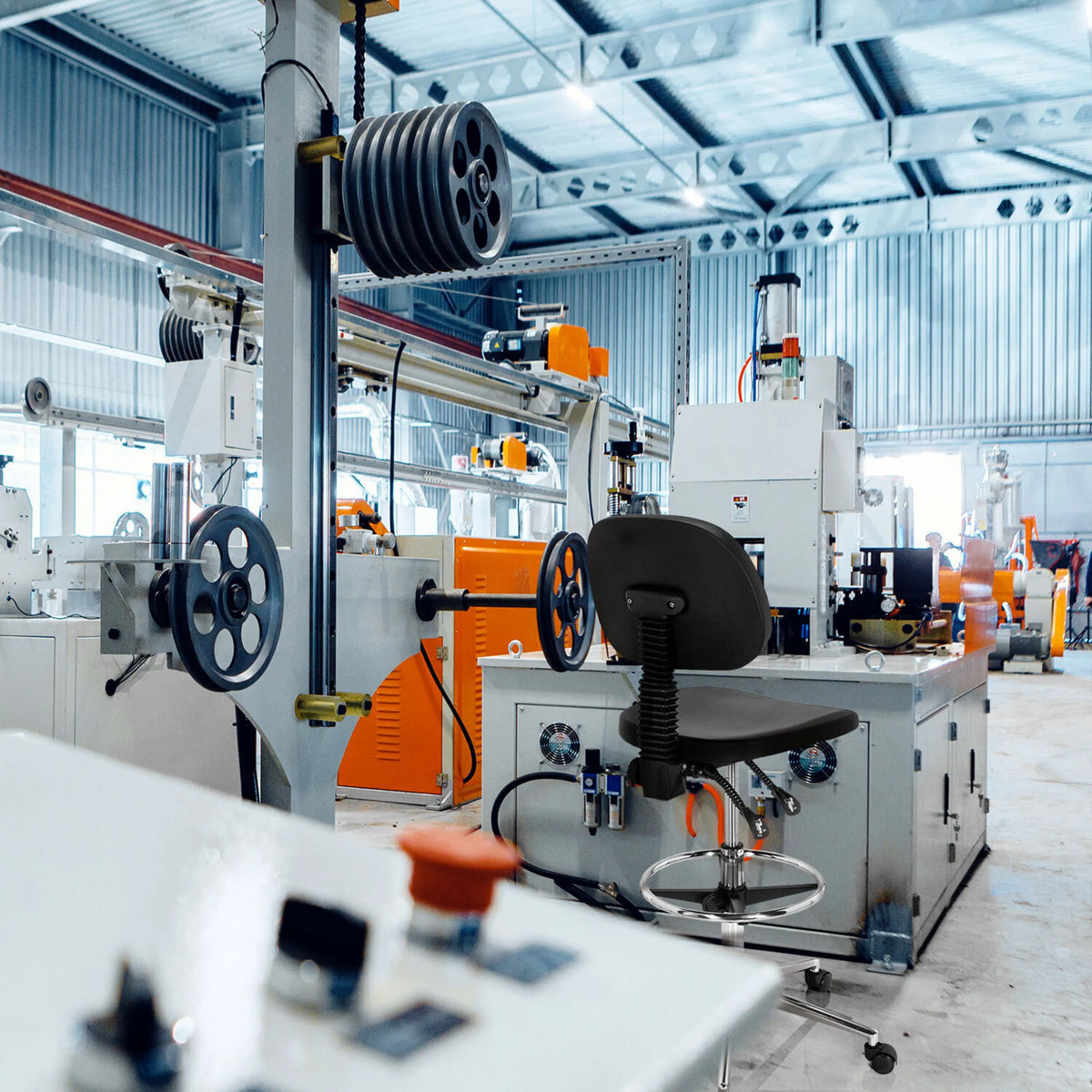 Sedia da banco nera TOP WORK 24 I con poggiapiedi in un capannone industriale di hjh OFFICE