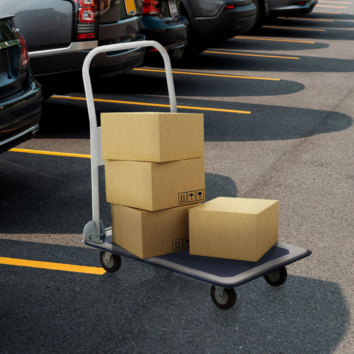 Carrello a piattaforma CARRY blu e bianco con tre scatole di cartone caricate in un parcheggio di hjh OFFICE