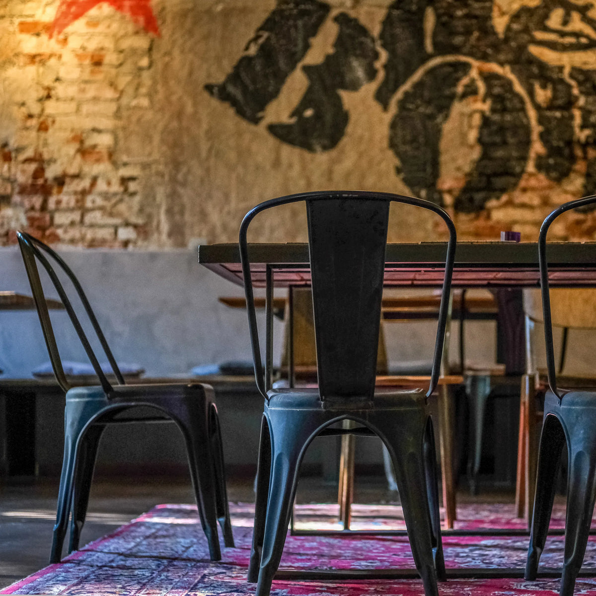 Vista posteriore di una sedia bistro VANTAGGIO BRUSH in metallo nero a un tavolo di hjh OFFICE