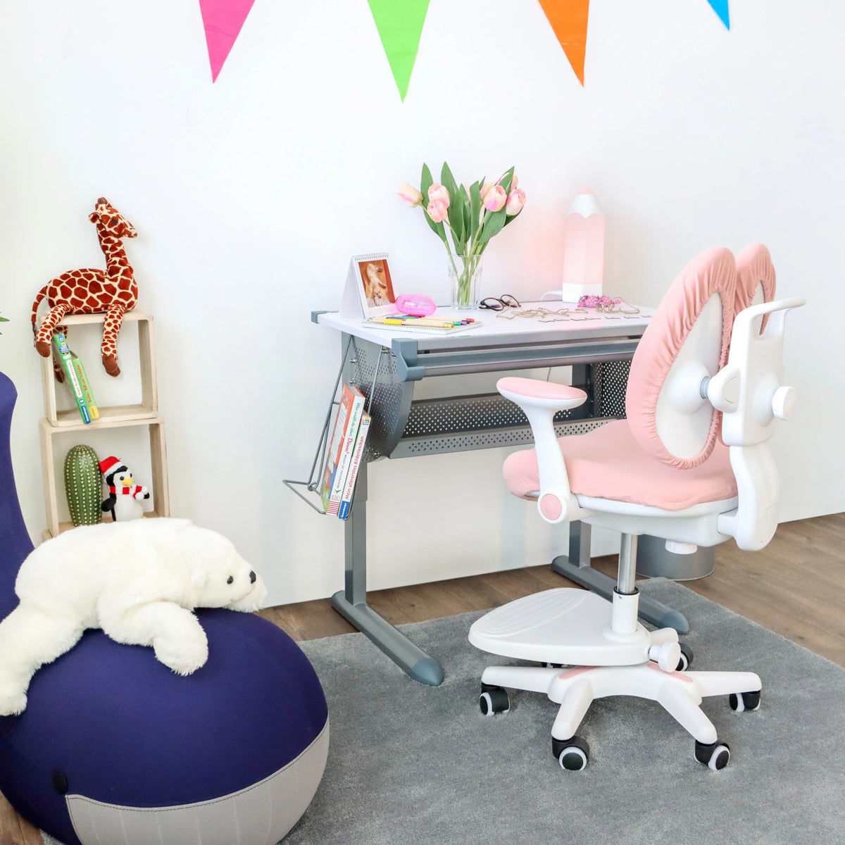 Sedia per bambini KID WING rosa con struttura bianca e ruote davanti a una scrivania per bambini di hjh OFFICE