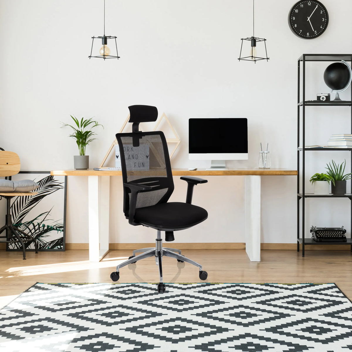 Sedia da ufficio professionale PROFONDO PRO nera con schienale in rete e poggiatesta davanti a una scrivania di hjh OFFICE