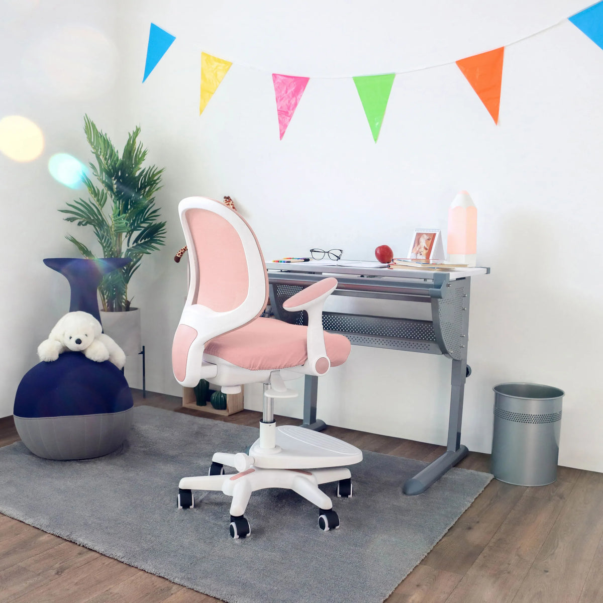 Sedia per bambini rosa KID ERGO con braccioli bianchi e rotelle a una scrivania di hjh OFFICE