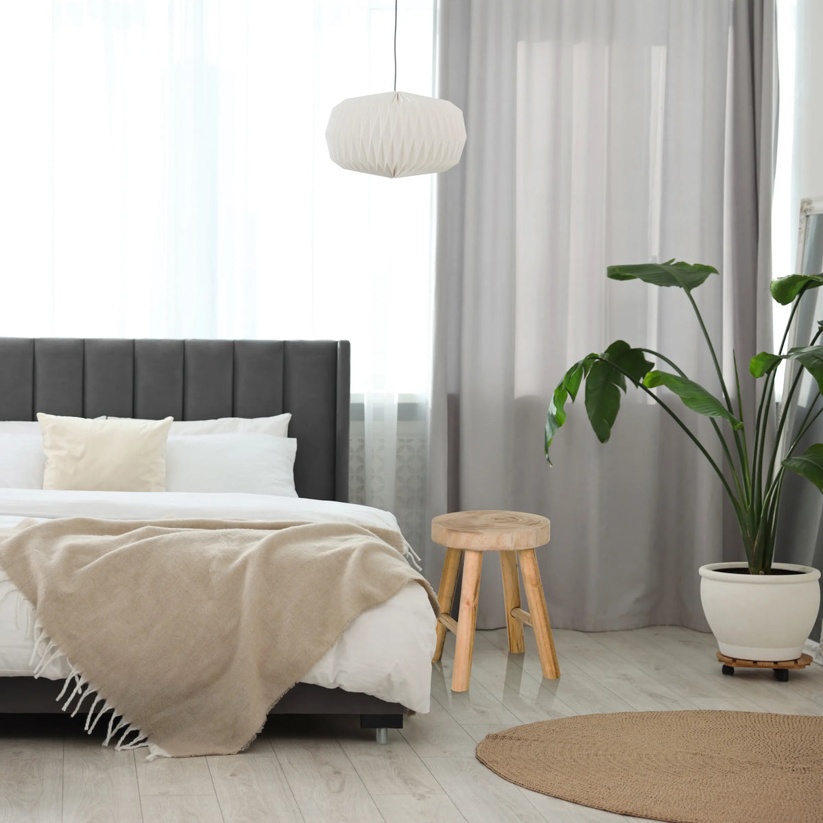 Sgabello RUSTIKO W in legno marrone con tre gambe accanto a un letto di hjh LIVING