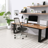 Sedia da ufficio high-end FOUNTAINE PRO in nero con schienale in rete davanti a una scrivania di hjh OFFICE