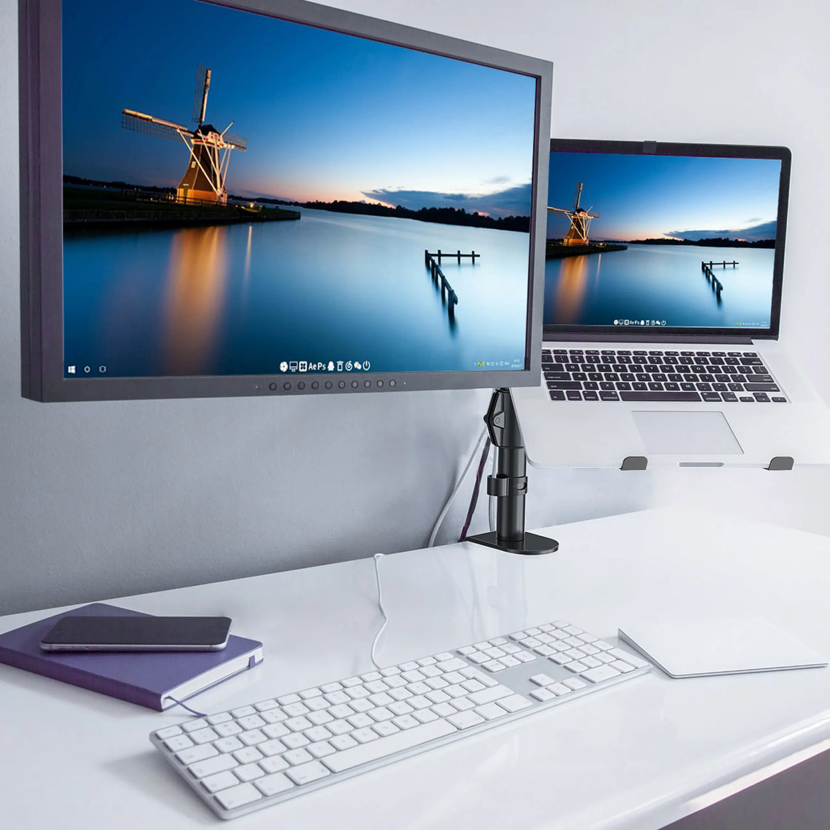 Supporto per monitor VM-MH2 nero con uno schermo fissato su una scrivania bianca di hjh OFFICE