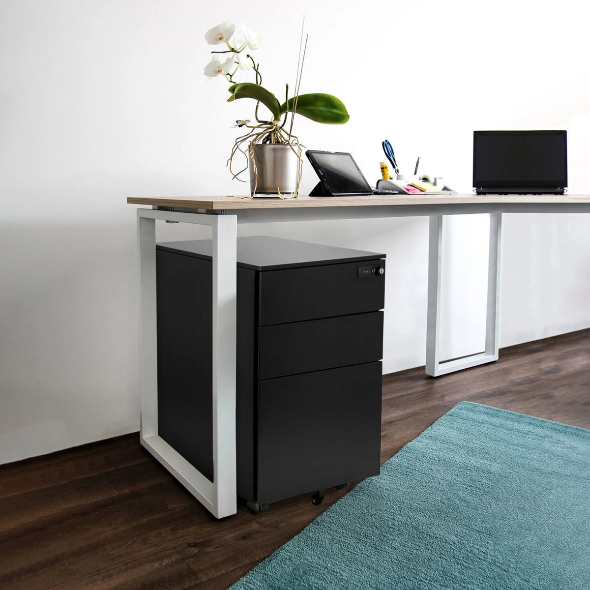 Cassettiera con rotelle in metallo nero COLOR OS I sotto una scrivania con piano in legno chiaro di hjh OFFICE
