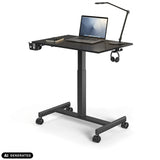Scrivania in piedi Stand K nera su ruote con laptop e lampada da scrivania di hjh OFFICE (immagine generata dall’IA)