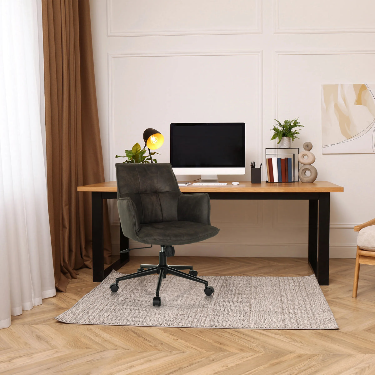 Sedia Home Office SOLAO LIFE grigio scuro con ruote e braccioli davanti a una scrivania di hjh LIVING