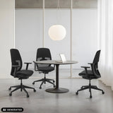 Tre sedie da ufficio professionali Skandis in nero a un tavolo rotondo di hjh OFFICE (immagine generata dall’IA)