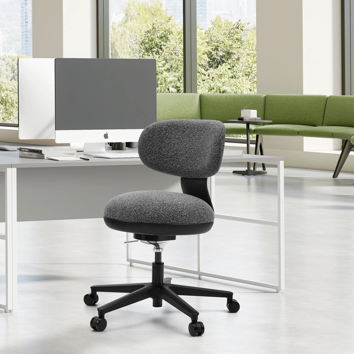 Sedia Home Office SITMOTION B grigia con rotelle davanti a una scrivania bianca in un ufficio luminoso di hjh OFFICE