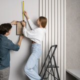 Scala richiudibile SOLID W6 nera a tre gradini utilizzata per appendere un quadro di hjh OFFICE