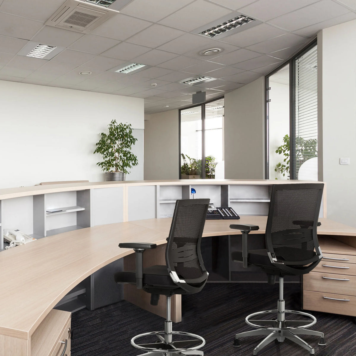 Due sedie da banco TOP WORK 77 nere con schienale in rete e poggiapiedi a un bancone della reception di hjh OFFICE