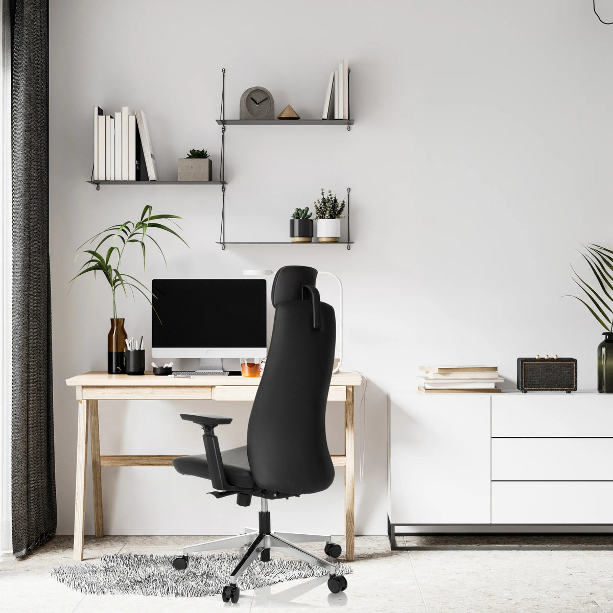 Poltrona professionale nera YUCANO I a una scrivania in una stanza luminosa di hjh OFFICE