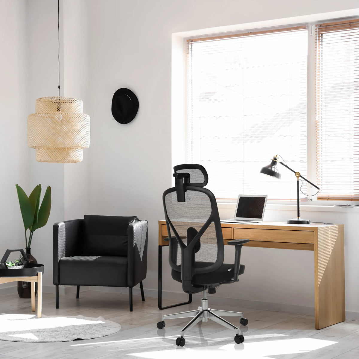 Sedia da ufficio professionale RALOO PRO in nero con schienale in rete e poggiatesta a una scrivania di hjh OFFICE