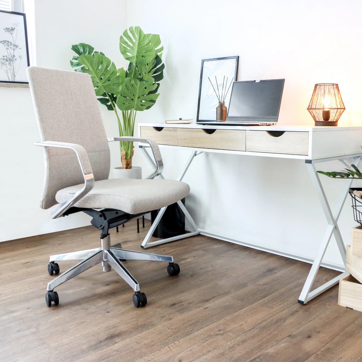 Sedia da ufficio professionale BESSONA in beige con braccioli e ruote davanti a una scrivania bianca di hjh OFFICE