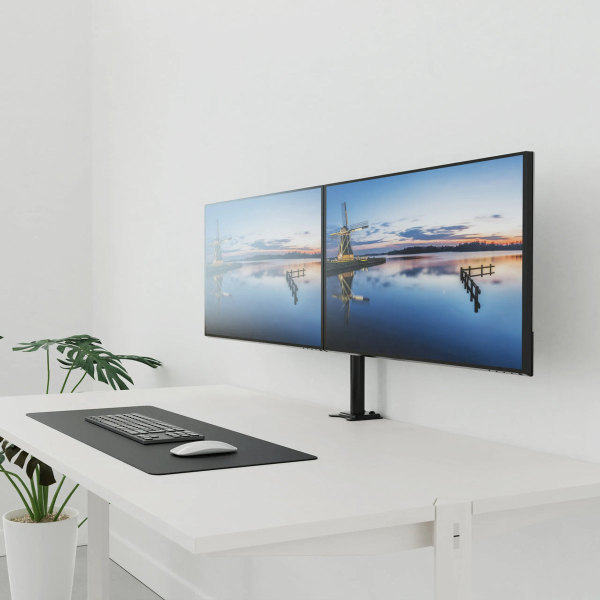 Supporto per monitor nero Ergomount M2 per due schermi su una scrivania bianca di hjh OFFICE