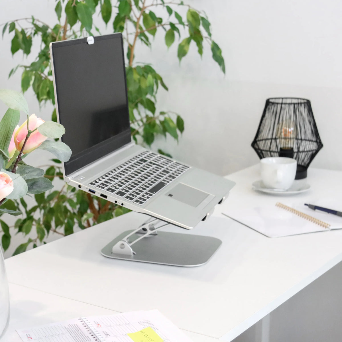 Supporto per LAPTOP STAND argento con struttura regolabile su una scrivania bianca di hjh OFFICE