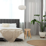Sgabello RUSTIKO W in legno marrone con tre gambe accanto a un letto di hjh LIVING