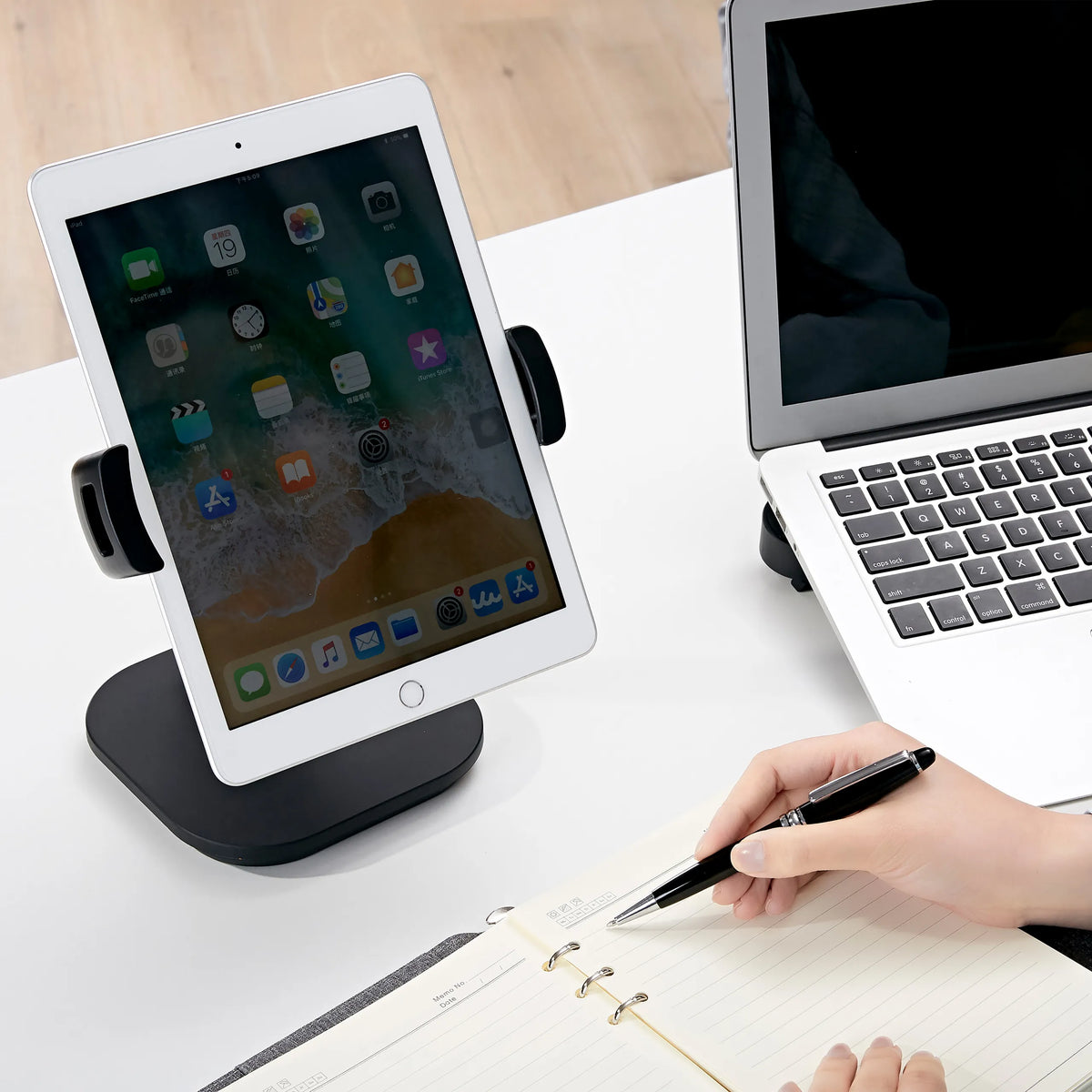 Supporto per cellulare e tablet FLEXMOBI IV nero con tablet inserito su una scrivania bianca di hjh OFFICE