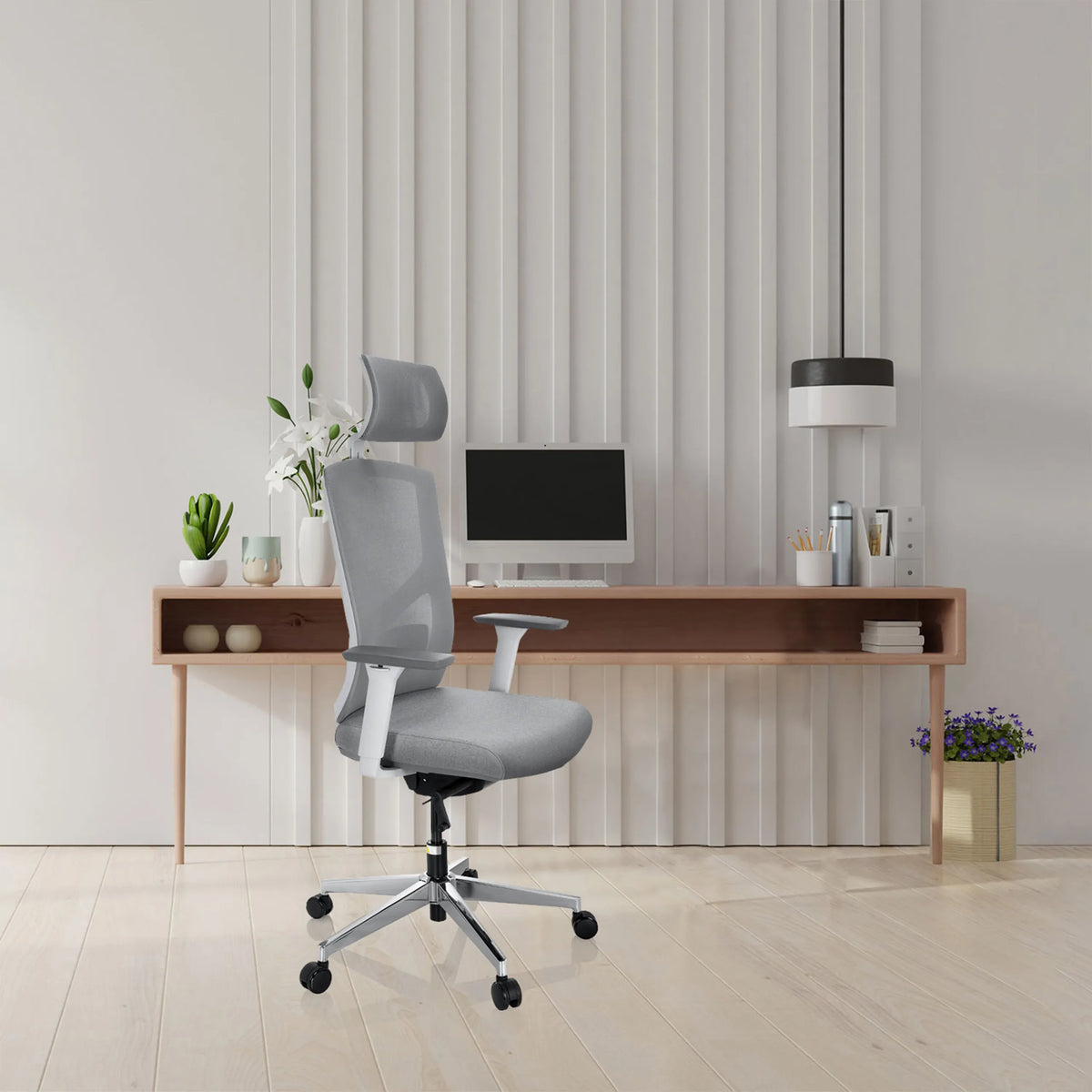 Sedia da ufficio professionale BRETON PRO W grigia con poggiatesta e braccioli davanti a una scrivania minimalista di hjh OFFICE